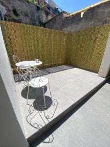eine Terrasse mit einem Tisch und Stühlen neben einem Zaun in der Unterkunft CASA ELISA in Capri