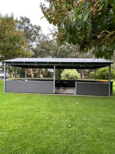 a gazebo with a bench in a park at Greenways Holiday Units in Tocumwal