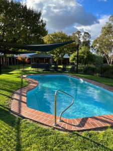 a swimming pool in a yard with a fence at Greenways Holiday Units in Tocumwal
