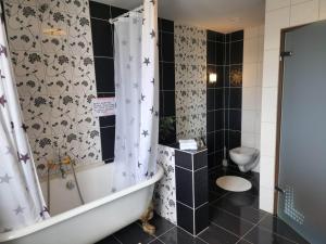 a bathroom with a bath tub and a toilet at Kiljan Apartments & Rooms in Blönduós