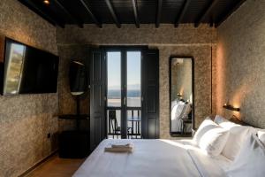 a bedroom with a bed and a view of the ocean at She Mykonos Boutique Hotel in Mikonos