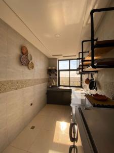 a large kitchen with a stove and a window at CosyApp in Agadir