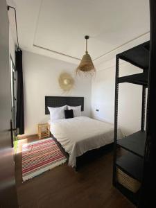 a bedroom with a bed with white sheets and a ladder at CosyApp in Agadir