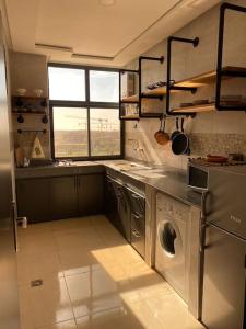 a kitchen with a washer and dryer in it at CosyApp in Agadir
