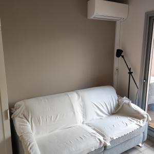un divano bianco in una stanza con una lampada di studio cabine quatre couchages classé 2 étoiles a Bormes-les-Mimosas