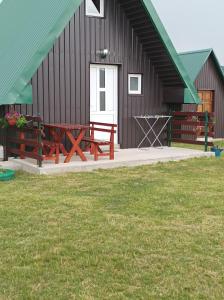 a building with two picnic tables in front of it at Apartman Jegdic-Zabljak in Žabljak