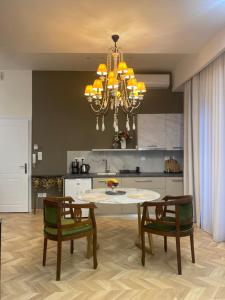 a kitchen with a table and chairs and a chandelier at Atelie home experience serres in Serres