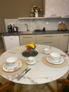 a table with plates and cups and a bowl of bananas at Atelie home experience serres in Serres +13 photos