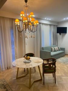 a living room with a dining table and a chandelier at Atelie home experience serres in Serres
