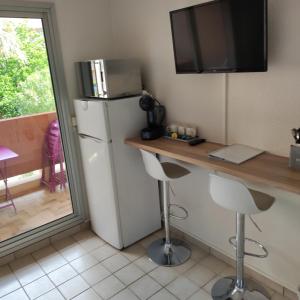 una cucina con frigorifero, tavolo e sedie di studio cabine quatre couchages classé 2 étoiles a Bormes-les-Mimosas