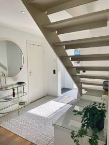 a living room with a staircase and a mirror at Modern, mysig & exklusiv villa i Skärgården #1 in Stockholm