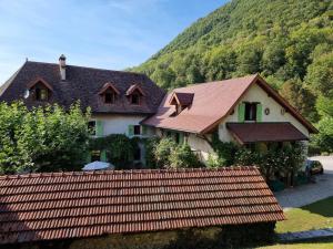 a house with a fence in front of a mountain at La Vallombreuse in Menthon-Saint-Bernard