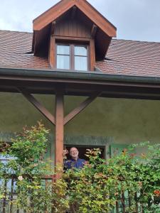 Ein Mann, der aus dem Fenster eines Hauses schaut. in der Unterkunft La Vallombreuse in Menthon-Saint-Bernard