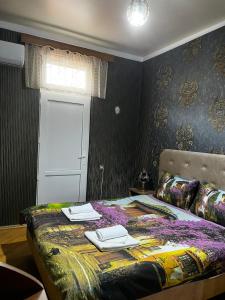 a bedroom with a bed with two towels on it at Sweet Memories in Kutaisi