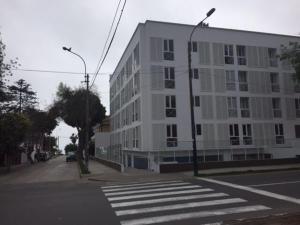un gran edificio blanco en una calle de la ciudad con un paso de peatones en Barranco Best Location - Apartment, en Lima