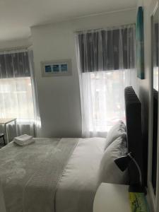 a bedroom with a bed and a desk with a television at En Suite Double Room 2 in Plumstead