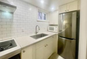 a kitchen with a stainless steel refrigerator and a sink at Urban KW Gem - Private 2 Bedroom Apartment ! in Kitchener
