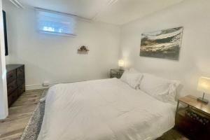 a white bedroom with a large bed and a window at Urban KW Gem - Private 2 Bedroom Apartment ! in Kitchener