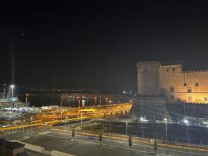 ein Gebäude mit einem Uhrturm in der Nacht in der Unterkunft La Dimora al Castello in Neapel