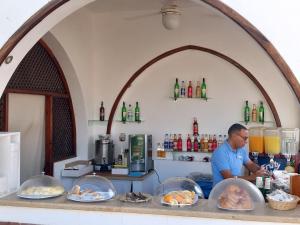 Ein Mann, der hinter einer Theke mit Teller voller Essen steht. in der Unterkunft Domina Coral Bay - Private One Bedroom Aparthotel in Sharm El Sheikh