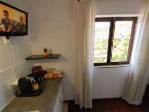 a bathroom with a window and a counter and a sink at Casa Hóspedes Polido in Termas de Sao Pedro do Sul
