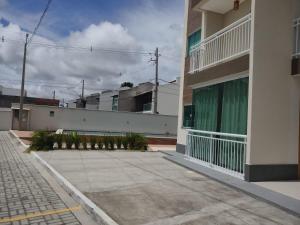 a building with a sidewalk in front of a building at Lençóis Confort - Apartamento in Barreirinhas