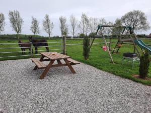 a picnic table with a swing and a playground at Maison individuelle in Pommeréval +12 photos