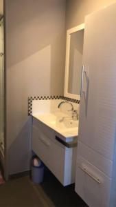 ein Bad mit einem Waschbecken und einem Spiegel in der Unterkunft Maison individuelle 