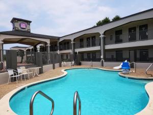 a pool in front of a hotel with a building at Express Inn Tomball in Tomball
