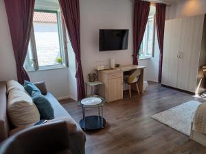 uma sala de estar com um sofá e uma secretária em JR Luxury Guesthouse em Split