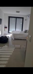 um quarto com uma cama e uma grande janela em Francia Uno em Rosário