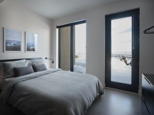 1 dormitorio con 1 cama y puerta corredera de cristal en Panorama Charlevoix - Pool, Spa, Exceptional View, en Les Éboulements