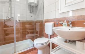 uma casa de banho com um WC, um lavatório e um chuveiro em Beautiful Apartment In Podgrade With Jacuzzi em Slime