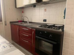 a kitchen with a stove and a sink at Lovely Marinella in Marinella di Sarzana