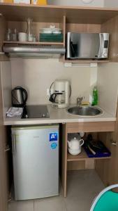 uma pequena cozinha com um lavatório e um frigorífico em Studio cosy résidence Odalys 3 Étoiles em La Londe-les-Maures