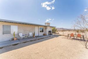 a house in the desert with chairs and a table at The Maude House in Twentynine Palms