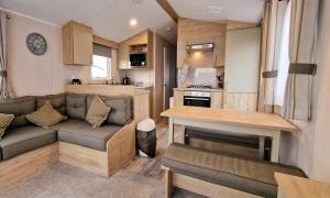 a living room with a couch and a kitchen at Modern 6 Berth Caravan With Wifi At Martello Beach In Essex Ref 28008pm in Clacton-on-Sea