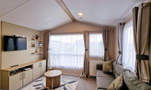 a living room with a couch and a tv at Modern 6 Berth Caravan With Wifi At Martello Beach In Essex Ref 28008pm in Clacton-on-Sea