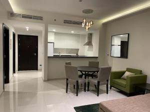 a kitchen and dining room with a table and chairs at Brand New Apartment with Gym and Pool in Dubai