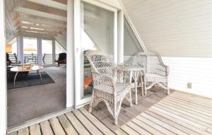 un patio con sillas de mimbre y una mesa en un porche en Beautiful Home In Assens With 3 Bedrooms And Wifi, en Assens