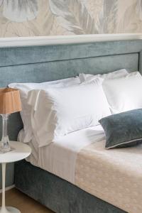 a bed with a blue headboard and white pillows at Florence Feel Apartment in Florence
