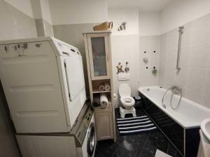 e bagno con vasca, servizi igienici e lavandino. di One Private room available in a two room apartment in Tegel, Berlin a Berlino