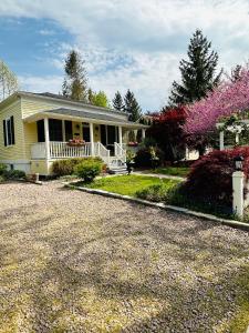 a yellow house with a porch and a driveway at Heritage House Niagara in Niagara on the Lake