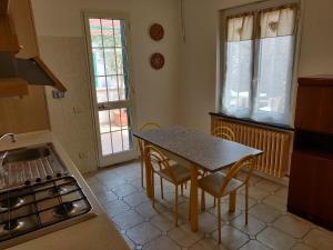 eine Küche mit einem Tisch, Stühlen und einem Waschbecken in der Unterkunft Casa Il Carruggio in San Bartolomeo al Mare