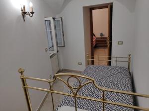 ein Schlafzimmer mit einem Metallbett in einem Zimmer in der Unterkunft Casa Il Carruggio in San Bartolomeo al Mare
