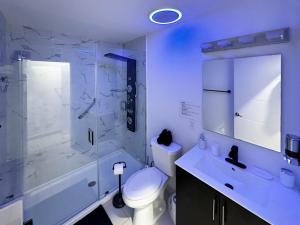 a bathroom with a shower and a toilet and a sink at Vacay Spot experience Luna Sky! 65" TV BAR, BBQ, SHOWER massage jets, music, go to FL Keys in Homestead