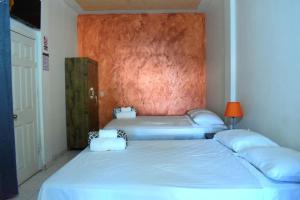 a bedroom with two beds and a wall at Casa Vieja Hotel y Restaurante in San Lorenzo
