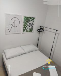 a bedroom with a white bed and a lamp at Angra Hostel 147 in Angra dos Reis