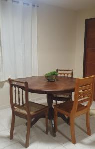- une table en bois avec 2 chaises et un bol sur le dessus dans l'établissement Pousada Morada dos Pássaros, à Pedro Leopoldo