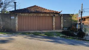 un garage marron avec un portail dans une maison dans l'établissement Pousada Morada dos Pássaros, à Pedro Leopoldo